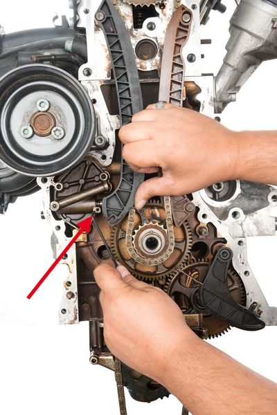 Abb. 14: Steuerkette entspannen. Spannschiene mit dem Finger gegen das Spannelement  drücken, ... (Contitech)