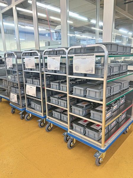 Le long de l'atelier, les chariots Kanban rythment l'approvisionnement de l'atelier et en particulier des Robodrill : un système de gestion de stock efficient qui sécurise les gains apportés par la standardisation et l'automatisation de la production. (Source : Marina Hofstetter)
