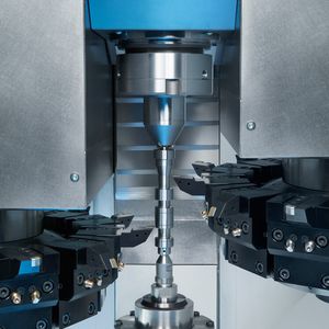 Das Beladen der VT 2-4 erfolgt über einen Greifer im Revolver. Dieser nimmt die Werkstücke von der seitlichen Werkstückzuführung auf und legt sie in die Spindel / den Reitstock.