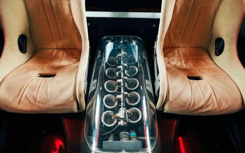 Eine transparente Motorabdeckung gibt den Blick auf den V10 frei – platziert zwischen den hinteren Sitzen. (Bild: Renault)