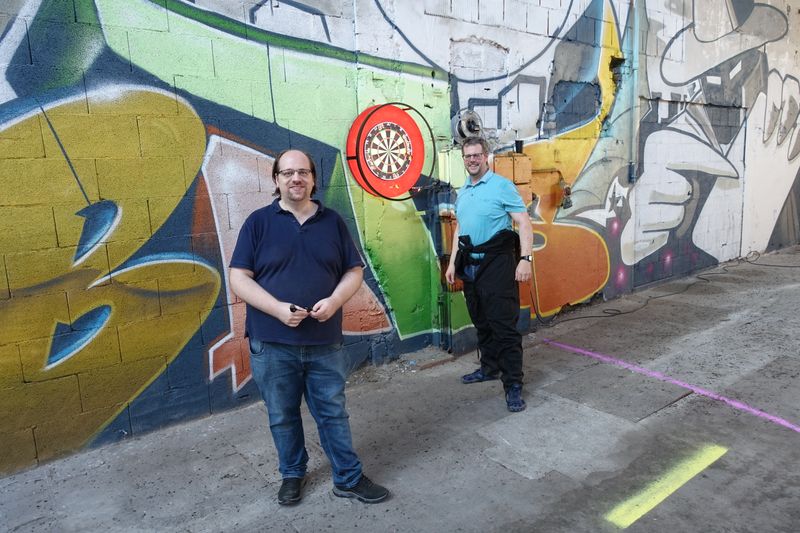 Norbert und Peter (r.) spielen eine runde Dart. (IT-BUSINESS)