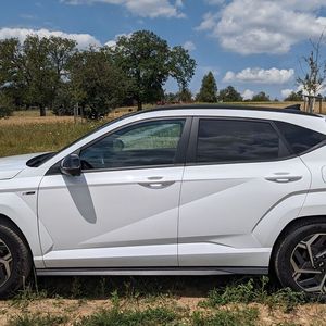 Markant geriet das Design des Kona. Der Hersteller spricht von einem „futuristischen Look“, was man zweifelsohne unterschreiben kann. Der von 2017 bis 2023 gebaute Vorgänger kam deutlich rundlicher daher. Nun bestimmen Ecken, Kanten und markante Sicken des Aussehen. Der weiße Farbton ist übrigens weder ein schnöder Uni- noch ein Metallic-Lack, sondern ein sogenannter Mineraleffekt-Lack. Er bietet einen Effekt ähnlich wie ein Metallic-Lack, nur stärker. Der Aufpreis von „Serenity White“: 850 Euro. Stichwort Aufpreis: Zusammen mit dem Glasschiebedach, dem bereits erwähnten Ulitmate-Paket und dem vorzüglichen Bose-Soundsystem kam unser Testwagen auf 43.650 Euro (Basispreis: 39.350 Euro).(Bild:  Dominsky – VCG)