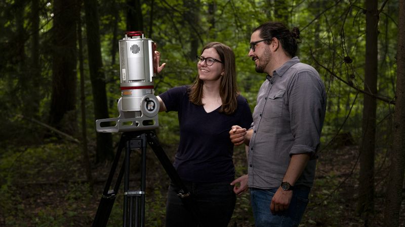 Dr. Katja Kowalski und Prof. Cornelius Senf bei der Arbeit mit einem Laserscanner. Der Scanner ermöglicht es, ein digitales, 3-dimensionales Abbild eines Waldes anzufertigen.(Bild:  Sebastian Kissel / TUM)