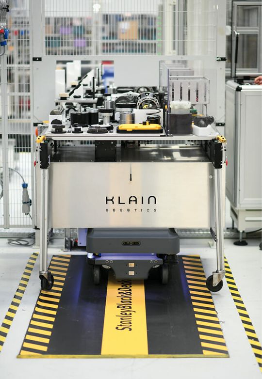 (Der MIR200-Roboter übergibt den beladenen Werkstückträger automatisch an die Roboterzelle. Bild: Mobile Industrial Robots (MIR))