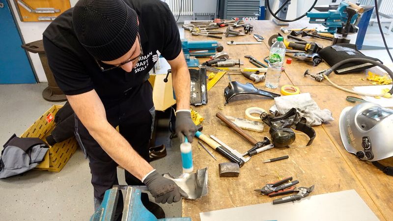 Der Drittplatzierte in der Karosserieinstandhaltungstechnik, Malik Arslan, bringt das Blech „mit Links“ in Form. (Bild: Dominsky – VCG)