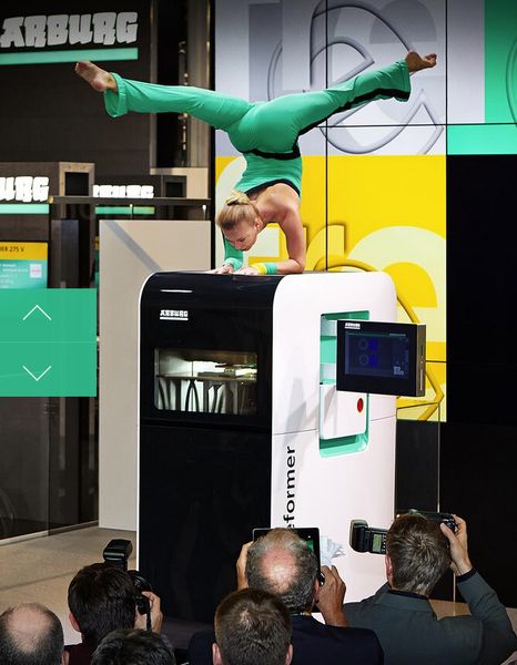 Une danseuse en guise de décor d'une machine Arburg lors de la dernière exposition K 2013. Les photographes sont certainement en admiration devant les formes arrondies de la nouvelle machine Freeformer. (Image: www.arburg.com)