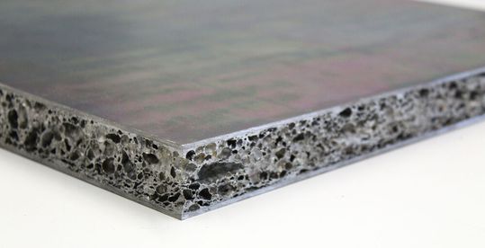 Das ist der Schnitt durch ein besonders leichtes Metallschaum-Sandwich. Es handelt sich im Inneren um Aluminiumschaum. Die Deckplatten sind aus Stahl oder Aluminium. Für die Forscher vom Fraunhofer IWU ist das die Chance für die Binnenschifffahrt bei Niedrigwasser.(Bild:  Fraunhofer IWU)