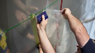 Sharkskin-Technologie: Ein Mitarbeiter von Lufthansa Technik bringt den Oberflächenfilm auf der Außenhaut einr B777F an. (Bild: Oliver Roesler)