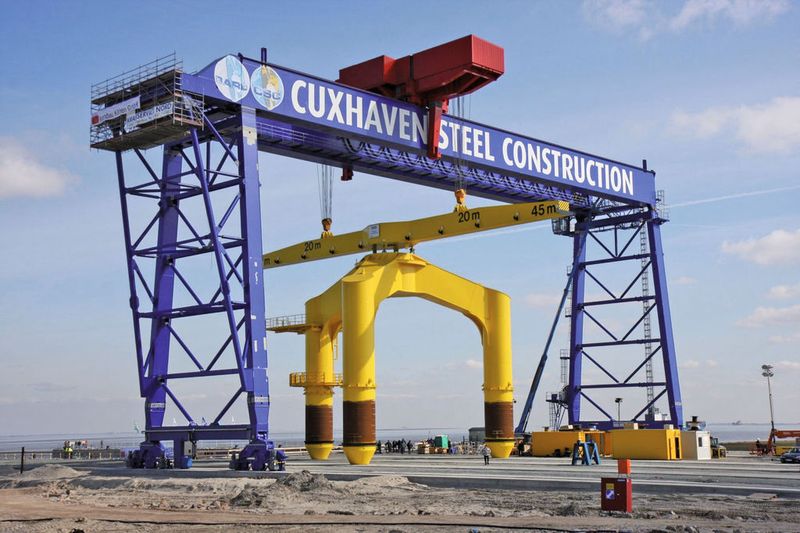 Eine BARD-Gründungsstuktur am 600-Tonnen-Kran der Offshore-Basis Cuxhaven. Von hier aus werden die Fundamentbauteile der Windkraftanlagen auf die Nordsee verschifft.  (Bild: BARD Gruppe)