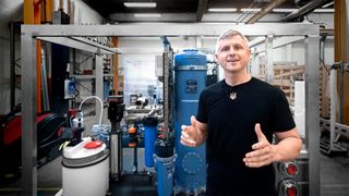 Oleksandr Sadchykov in front of the water treatment unit (Source: Grundfos)