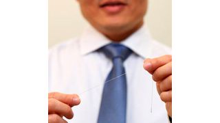 Der an der NUS (National University of Singapore) entwickelte neuartige Mikrofaser-Sensor, der wie ein leitfähiger Faden funktioniert, ist hochempfindlich und ultradünn. Der Sensor besitzt gerade einmal den Durchmesser einer menschlichen Haarsträhne. Entworfen, um haltbar und waschbar zu sein, bietet diese Erfindung vielversprechende Anwendungsmöglichkeiten im Bereich der tragbaren Elektronik. (National University of Singapore)