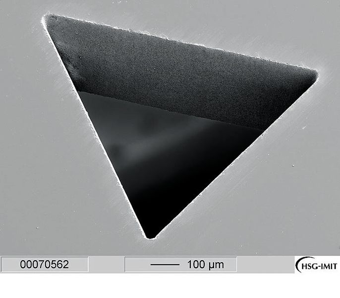 Bild 7: Der dreieckige Durchbruch in einem Saphirplättchen hat auch unter dem Elektronenmikroskop bis in die Spitzen fast perfekte Kanten. (Bild: Trumpf)