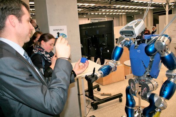 Ein lauffähiger Roboter ergreift autonom einen Würfel und übergibt ihn Matveev Nikita, russischer Generalkonsul in München. (Bild: Matthias Endres)