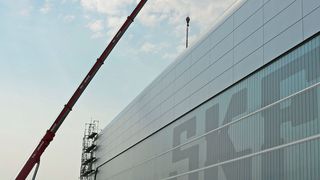 Ein 220-Tonnen-Kran draußen – ein 7,5-Tonnen-Gewicht drinnen: Mitarbeiter von Kühnezug befestigen eine der beiden Laufkatzen des Hauptkrans am Haken. (SKF)