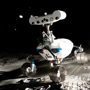 LRU1 kartiert die Oberfläche visuell und in 3D. Dazu nimmt er die Oberfläche mit einer multispektralen Stereopanorama-Kamera auf, die an seinem breiten „Kopf“ gut zur erkennen ist. Solche Kameras sehen weit mehr als „nur“ Farben. Sie messen Bilddaten in Wellenlängenbereichen, die weit über das hinausgehen, was das menschliche Auge wahrnehmen kann. Auf dem Mond können so Informationen über die mineralogische Zusammensetzung der Oberfläche erfasst, kartiert und quantifiziert werden. Forschende haben in der LUNA-Halle Messwerkzeuge und Roboter getestet, die Wassereis auf dem Mond finden können.(Bild:  LRU1 erfasst die Oberfläche in der LUNA-Halle mit seinen Spezial-Kameras /DLR / CC BY 3.0)