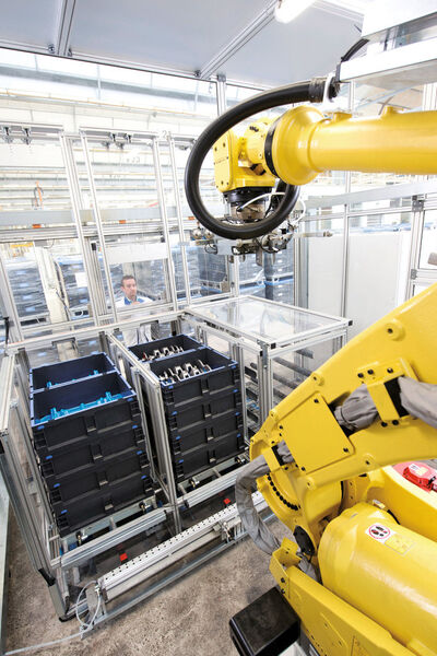 Die Kurbelwellen werden automatisch per Roboter in QX-Behälter verpackt, in drei nebeneinanderliegenden Stapelboxen nach chaotischem System. (Bild: SSI Schäfer)
