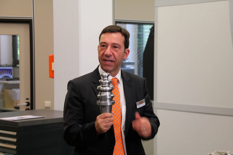 ...Verkaufsleiter Jens Löscher zeigt. Er hält einen Werkzeugrohling in der Hand. (Andrea Gillhuber, MM Maschinenmarkt)