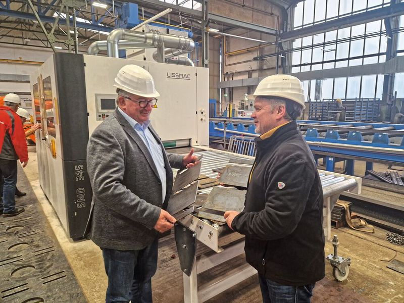 Roland Möbius, zuständig für den Bereich Zuschnitt in der Brückenwerkstatt Dresden und Dirk Schürstedt, Gebietsverkaufsleiter Metal Processing bei Lissmac, prüfen das Ergebnis des Kantenverrundungs-Prozesses. (Bild: Brückenwerkstatt Dresden, Christian Hahn)