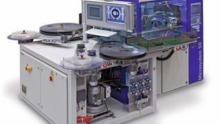 Bild 1: Zum Umspritzen metallischer Stanzteile werden Bänder mit den vorgestanzten Teilen von Spulen 
abgewickelt und durch eine Form in einer Spritzgießmaschine für Mikroteile transportiert.  (Bild: Heraeus)