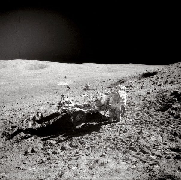 Vue du flanc de « Stone Mountain » (la montagne de pierre). John Young affairé à ranger les outils dans le rover après la seconde EVA sur le site d'alunissage de Descartes. (Image:NASA)