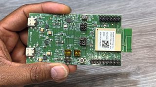 Detailaufnahme des Evaluation-Kits für den neuen SYN765x-Chip. Dieses Entwickler-Board ist das Herzstück der Smart-Home-Demonstration rund um die intelligente Mikrowelle. Ausgestattet mit einem aufgesetzten Ampak-Funkmodul samt Antenne, USB-C-Ports und weiteren Entwickler-Schnittstellen, übernimmt die Platine autark KI-Sensorik-Aufgaben sowie die Steuerung als IoT-Hub für Standards wie Wifi 7, Thread und Matter. (Bild: mc/VCG)