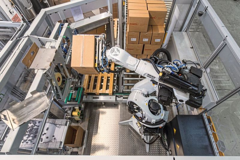 Am Ende des Verpackungsprozesses wartet ein weiterer KR Quantec, der die Firma Hauff beim Palettieren unterstützt, auf die Oberkorbrollen. (Bild: Kuka Group)