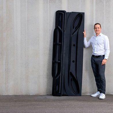 Hier ein guter Vergleich, welch große Kunststoffteile sich mit Queen-1-Anlagen von Herrmann Additive drucken lassen. Es handelt sich dabei um einen Heckleuchtenträger für den Caravan-Bau. Es dient als Funktionsmuster und punkte durch seine Komplexität und der dünnen Wandung. (Bild: Herrmann Additive)