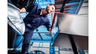 Ein Mitarbeiter eines Kfz-Betriebs überprüft beim Licht-Test die Beleuchtung eines Fahrzeugs.  (Bild: ProMotor)