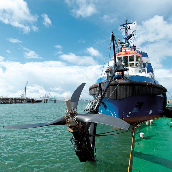 CFK-Rotor für ein Gezeitenkraftwerk. Seine Flügel stellen sich selbsttätig auf die Strömungsverhältnisse ein. Das Bild zeigt die Gesamtturbine an der abklappbaren Testvorrichtung eines Hochseeschleppers. (Bild: Schottel)