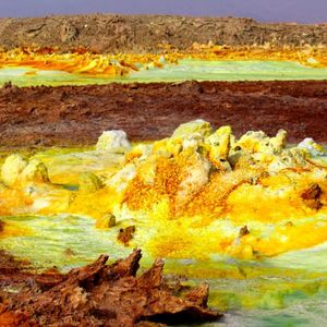 The sampling site. Samples were taken from the central yellow outcrop and water from the blue pool at the bottom of the chimney.
