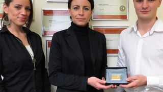 Nadine Wagner und Andreas Hoffmann von Terrabit nehmen den Goldbarren von Agnes Bergk entgegen. (Bild: Ebertlang)