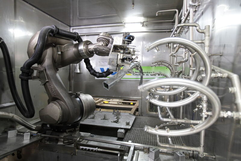 Die Umgebung, in der der Kuka-Roboter seine Tätigkeit ausführt, ist für Industrieroboter normalerweise nicht geeignet, denn der Roboter ist großen Wassermengen ausgesetzt, denen zu 3% noch alkalische Reiniger beigesetzt sind. Daneben herrschen in der Wasch-zelle Temperaturen von 60°C , was zu erheblichem Wasserdampf führt. Damit der Roboter durch die äußeren Einflüsse nicht zu Schaden kommt, wurden besondere Schutzvorrichtungen getroffen. (Kuka)