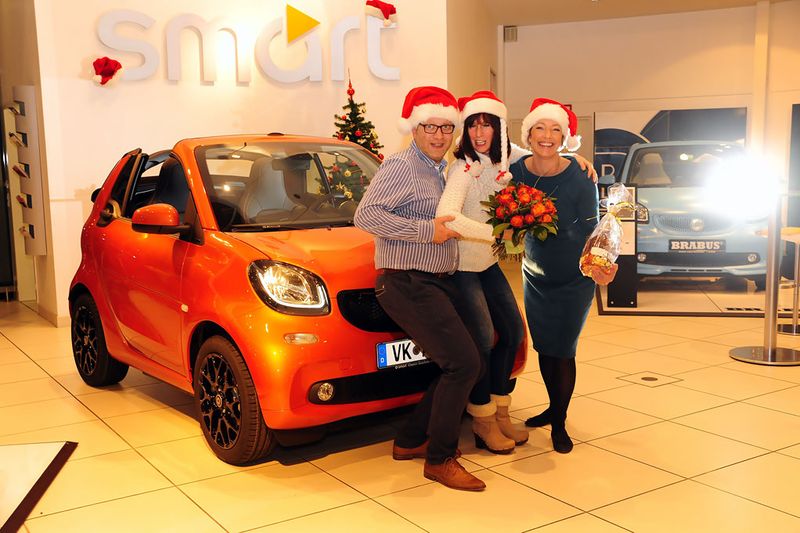 Das Jubiläumsauto ist ein Smart Fortwo Cabrio in lavaorange. Es ging in der Vorweihnachtszeit 2016 an die Dame in der Mitte, Anette Fröhlinger. Katrin Heinig und Sascha Vogel vom Smart-Center Saarbrücken feierten den Anlass gemeinsam mit der Kundin. (Wolfgang Klauke)