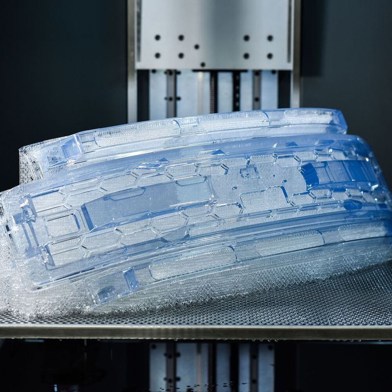 Covestro's additive manufacturing business includes one of the world's most recognized and trusted brands in photopolymers — Somos. The automotive grill shown here on a Stratasys Neo800 stereolithography system was 3D-printed with clear Somos Watershed CX 11122.