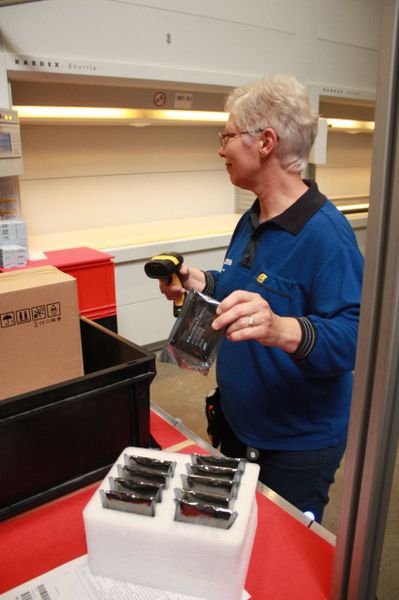 Frau Lauer scannt die Belege ein und entnimmt anschließend dem Kardex-Shuttle die angeforderte Ware. (IT-BUSINESS/Sarah Maier)