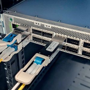 HPE/Juniper-PTX-Router im LGI Lab: Die Schlüssel des QDK-Moduls (mittig) werden verwendet um die Verbindung zwischen den 800G-Pluggables von Coherent Corp. (links) zu verschlüsseln.(Bild:  CUbIQ Technologies / HPE)