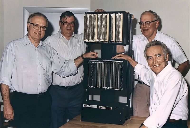 Die Pioniere der digitalen Relaislogik: Das Entwicklerteam um Richard „Dick“ Morley (im Bild ganz links) mit einem frühen Modell der Modicon 084. Ihre Entscheidung für den visuellen Kontaktplan sicherte der neuen Technologie die Akzeptanz in den Werkhallen. (Bild: Schneider Electric)