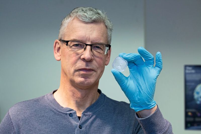 Untersuchungen geringster Materialmengen: Kosmochemiker Prof. Frank Brenker zeigt drei Körnchen eines Meteoriten, mit dem das Team der Goethe-Universität Untersuchungsmethoden vorab testete. Die Menge und Art entsprach dem Material des Asteroiden Bennu. (Bild: Uwe Dettmar für Goethe-Universität)