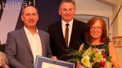 Staatsminister Hubert Aiwanger (l.) und Obermeister Michael Krammer (r.) ehrten Brigitte Schref, die sich seit 40 Jahren für die Kfz-Innung Niederbayern ehrenamtlich engagiert. (Bild: Zietz - VCG)
