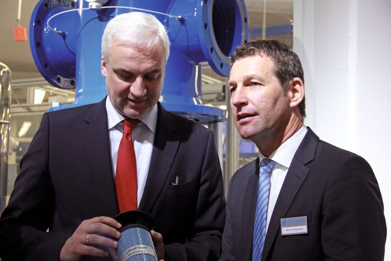 Auch Politiker zeigen Interesse: NRW-Wirtschaftsminister Garret Duin (links) lässt sich von Donaldson-Geschäftsführer Heiner Carstensen den neuen Druckluftfilter erklären. (Bild: Itasse)