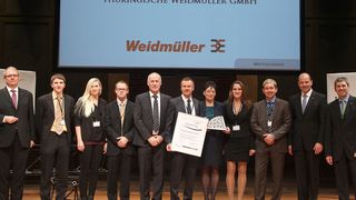 Ulrich Halbey (5.v.l.), Werkleiter in Thüringen, Bettina Geißhirt (7.v.l), zuständig für das Weidmüller Produktionssystem am Standort, und Stephan Köhler (6.v.l), Leiter Qualitätsmanagement vor Ort, nahmen stellvertretend die Ehrung mit dem 2. Platz des Ludwig-Erhard-Preises entgegen. (Bild: Weidmüller)