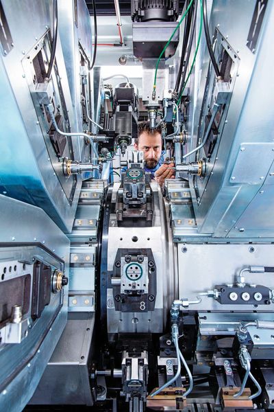 Der doppelt gelagerte vertikale Rundtisch (Bildmitte) dreht sich um eine horizontale Achse. Er taktet die Werkstücke innerhalb von 0,4 Sekunden mit einer Positioniergenauigkeit von +/- 0,002 Millimetern von Station zu Station. (Mikron SA Agno)