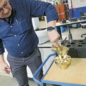 Henryk Fray, Fertigungsleiter Armaturentechnik, mit einem Bordventil. Die wirtschaftliche Bearbeitung des aus einer speziellen Bronze bestehenden Teils stellt grosse Anforderungen an das Zerspanungs-­Know-how und Fertigungs­equipment. (Bild:  Haimer)