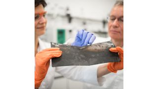 Prof. Jörg Acker und die wissenschaftliche Mitarbeiterin Jana Ducke untersuchen eine Kathodenfolie, die aus einer Lithium-Ionen-Batterie eines Elektroautos nach dessen Demontage entnommen wurde. (BTU Cottbus-Senftenberg)