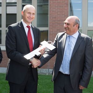 Herr Frank Leuze übergibt den symbolischen Schlüssel an Herrn Dr. Matthias Kirchherr, Geschäftsführer von Leuze electronic.