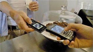 Schnell ausgetauscht: Per Smartphone werden Daten zwischen Kurier und Empfänger übertragen. Dann wechselt das Paket den Besitzer.  (Bild: Hasso-Plattner-Institut)