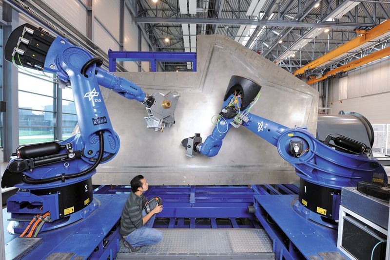 Grofi: effizientes Tapelaying und Fiberplacement mit CNC-Robotern. Sie arbeiten den Ablegeplan eines Teils gemeinsam ab oder bearbeiten mehrere Werkstücke parallel. Die Roboter werden vom Leitrechner mit Programmen versorgt, auch der Aufgabenstart kommt aus der Warte. (Bild: Siemens)