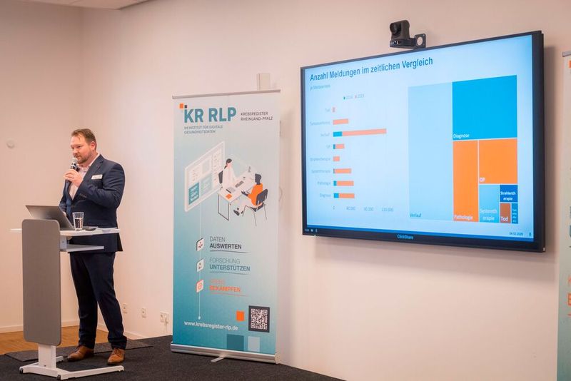Die Geschäftsführer des IDG, Philipp Kachel und Dr. Katja Schwarzer, hielten nicht nur die Eröffnungskeynote, sondern ergänzten den Rückblick von Swietlik mit Zahlen und Fakten. Kachel ging beispielsweise auf die Anzahl der Meldungen von 2016 bis 2025 ein und verglich diese je nach Anlass. (Bild: © Institut für digitale Gesundheitsdaten RLP)
