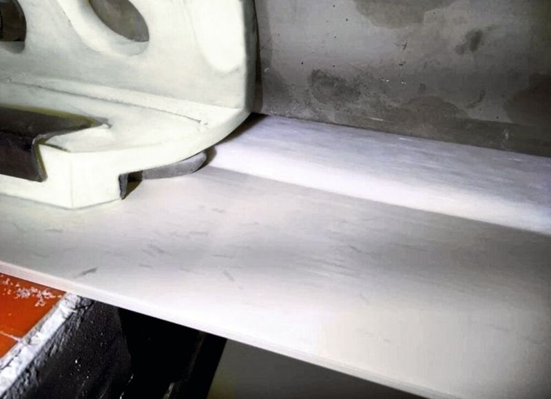 Der Airscrape in Aktion in der Zuckerindustrie. Am Ende der Übergabestelle schieben die Lamellen den vom Luftstrom zurückgehaltenen Zuckerstaub sauber zurück auf das Band. Die Umgebung bleibt sauber – und ohne Staub-Ex-Risiko. (Bild: Scrapetec)