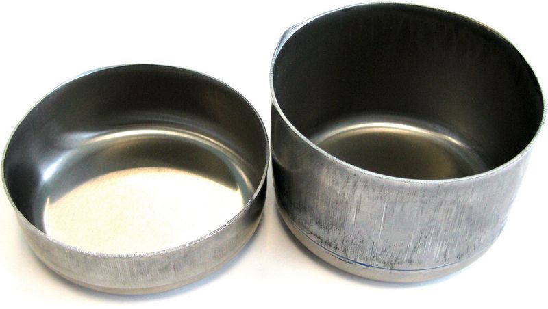 Bild 1: Der Näpfchenziehversuch zeigt, dass hochfeste Blechwerkstoffe aus Aluminium bei einer Temperatur um 200 °C eine deutlich bessere Umformbarkeit aufweisen (rechts) als bei Raumtemperatur (links). (IFU Stuttgart)